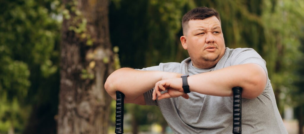 Man taking GLP-1 weight loss medications like Ozempic doing exercise at outdoor gym to lose weight.