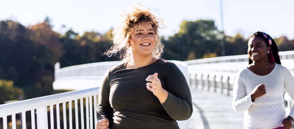 Two ladies running on sunny day outside emphasizing exercise as part of a sustainable GLP-1 medical weight loss journey with Ozempic and Wegovy.