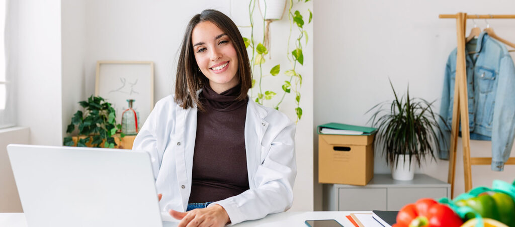 A registered dietitian consults with a GLP-1 medical weight loss patient via telemedicine in her office explaining the importance of balanced meal plans