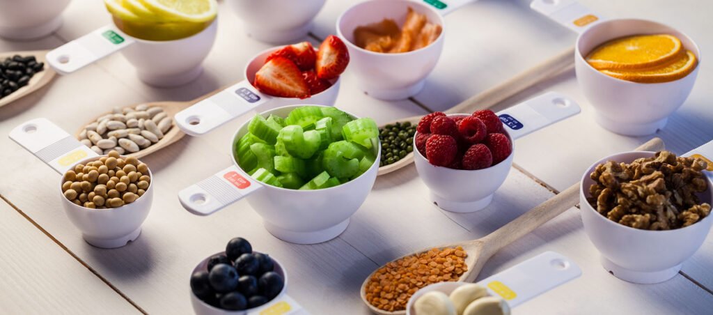 Measuring cups with healthy, nutritious food highlighting the importance of consuming a balanced diet while taking Ozempic and other GLP-1 medications for weight loss