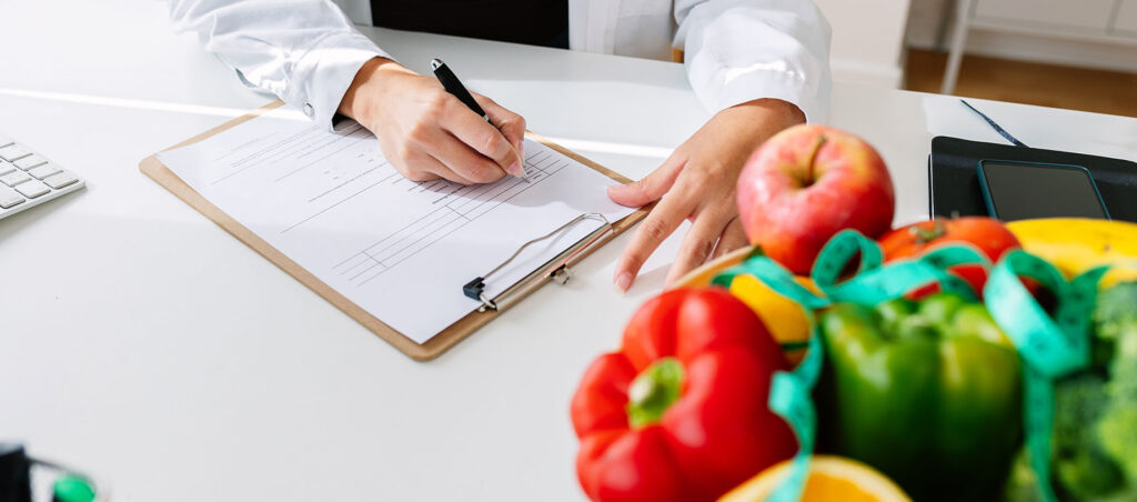 Female registered dietitian specializing in medical weight loss with GLP-1 prescriptions like Trulicity and Victoza laying out healthy food examples on office table for patients