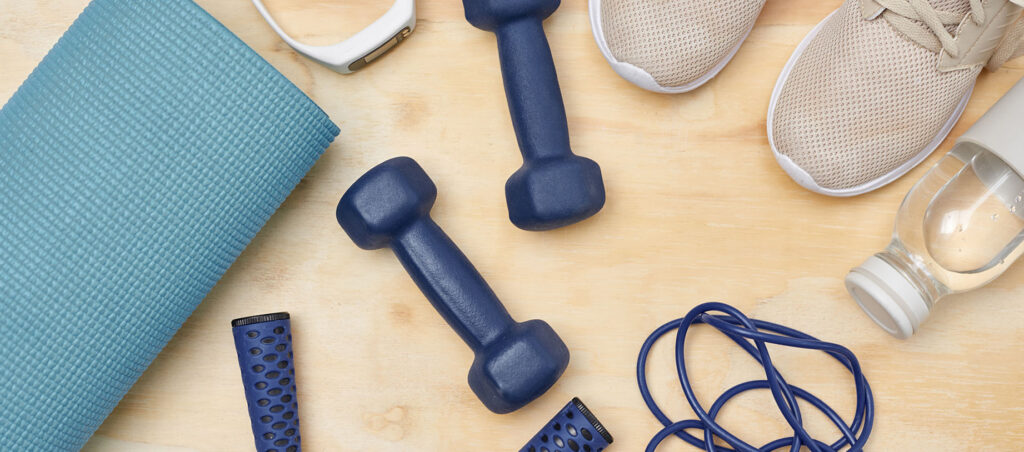 Assorted weight loss and exercise tools on wooden table showing the importance of prioritizing physical fitness while taking GLP-1 medications like Ozempic, Wegovy, Trulicity, Mounjaro, and Victoza