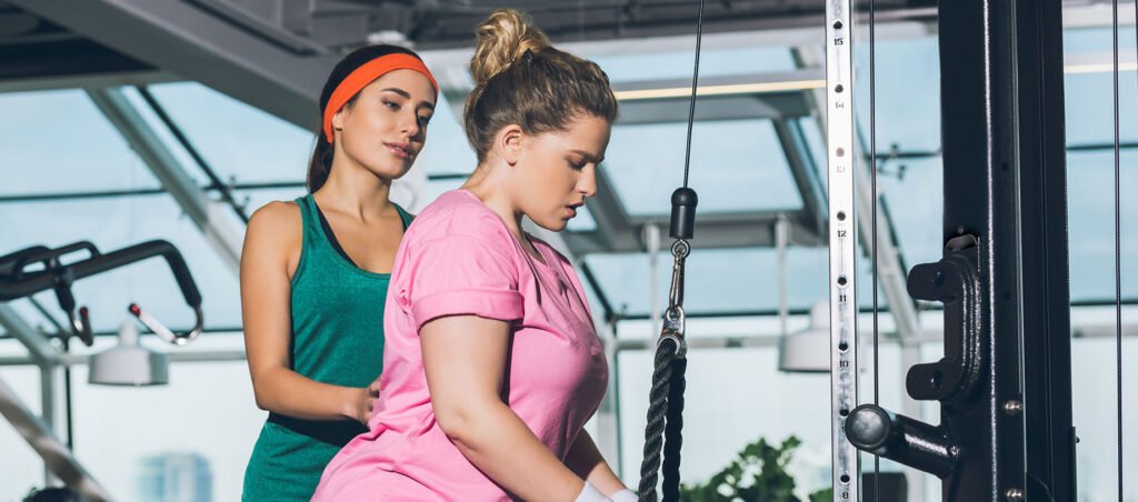 Lady exercising with personal trainer in gym to support nutrition, weight loss, and mindset along her GLP-1 journey with prescription Semaglutide (Ozempic)