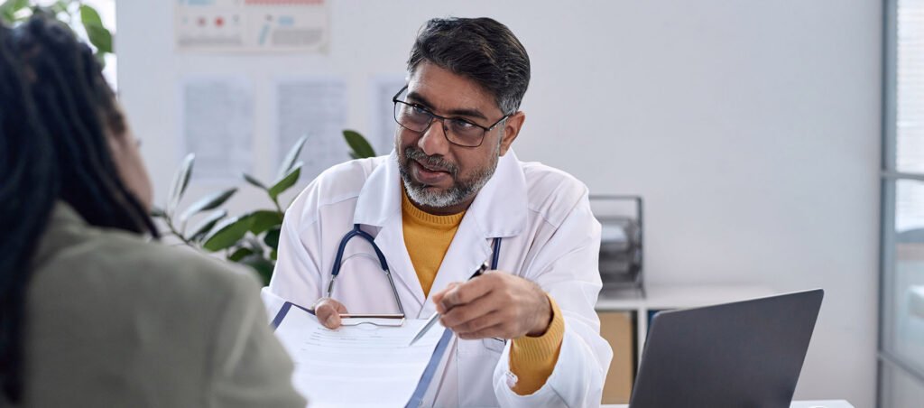 Doctor explaining his comprehensive approach to obesity medicine while speaking with patient during initial consult in a hospital setting