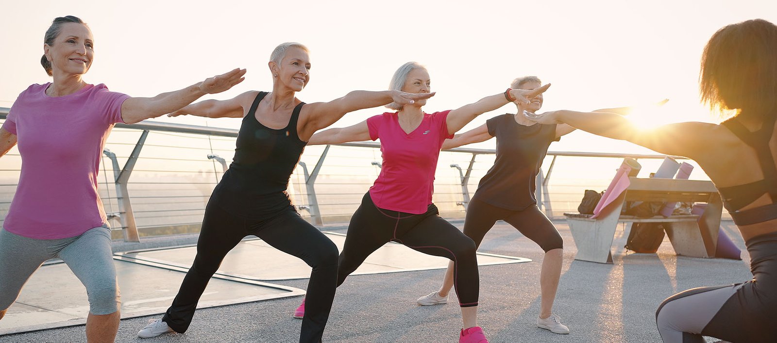 Older ladies doing yoga on a rooftop to focus on holistic wellness.
