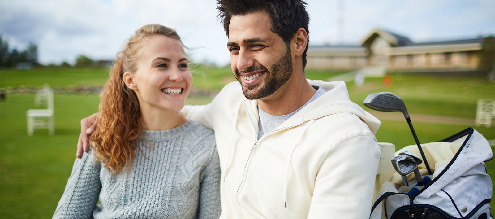 Happy husband and wife resting at a country club during a golf match for exercise and wellness.