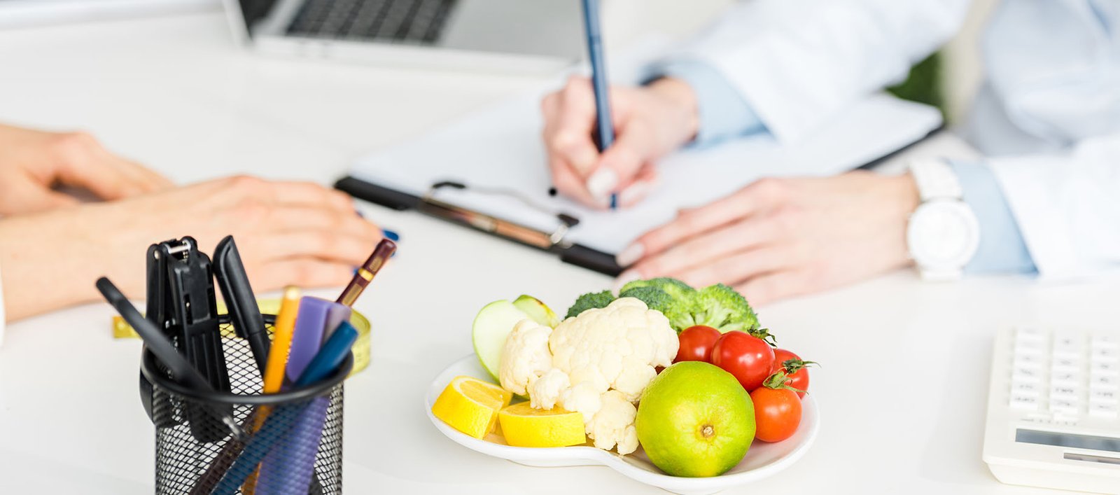 Dietitian making notes in a medical office documenting a meal plan for a patient taking GLP-1 medications for weight management and wellness.