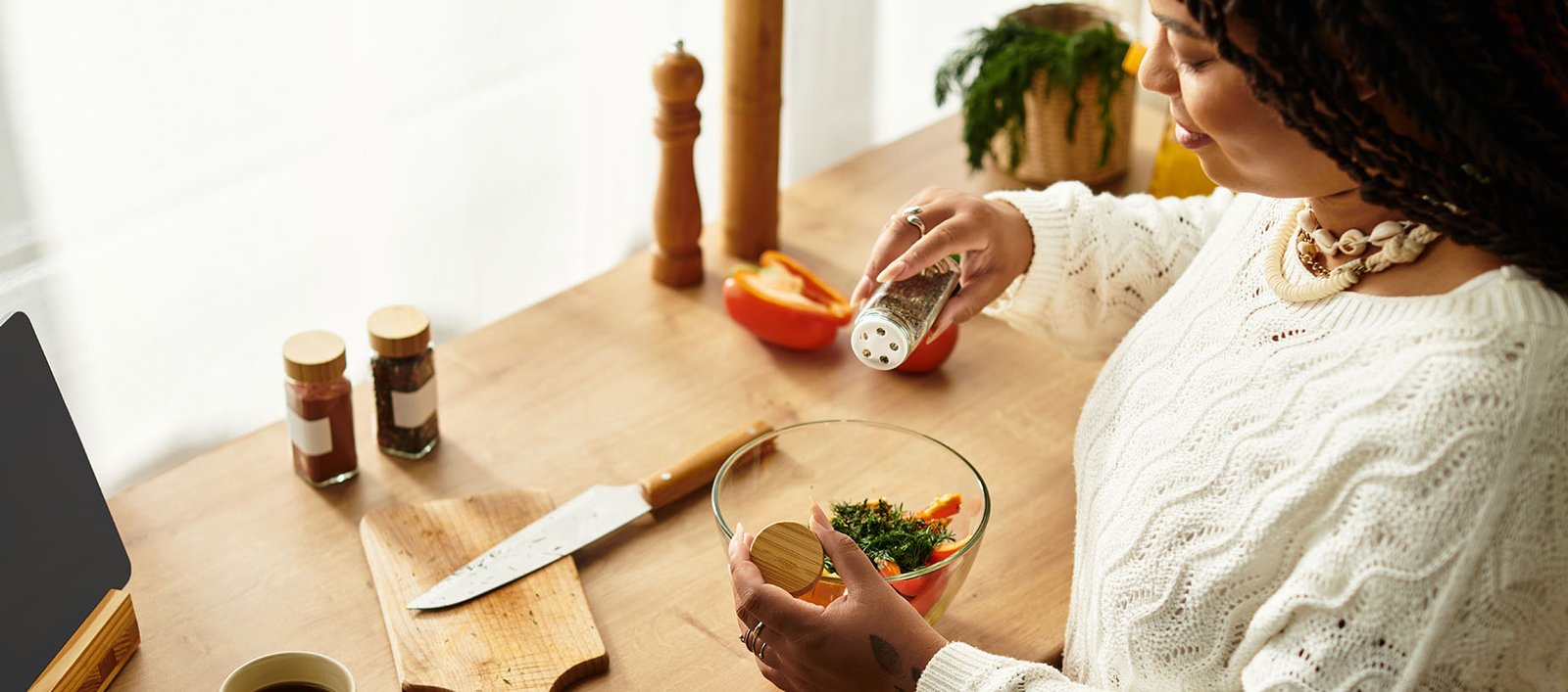 Lady cooking healthy salad in kitchen while prioritizing nutrition on her weight management journey with GLP-1 medications.