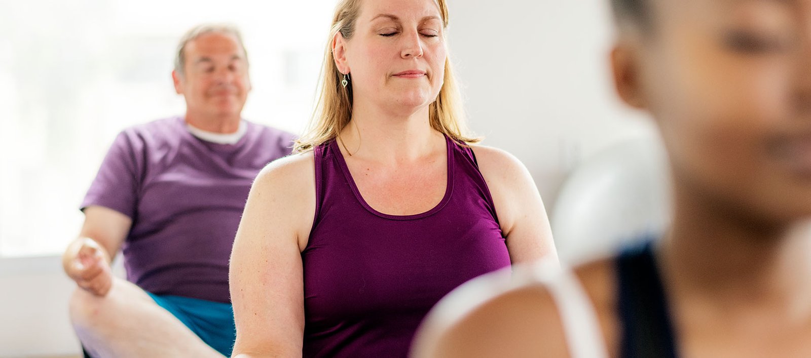 Group of country club members at a yoga and meditation class for stress relief, weight loss, wellness, and longevity.