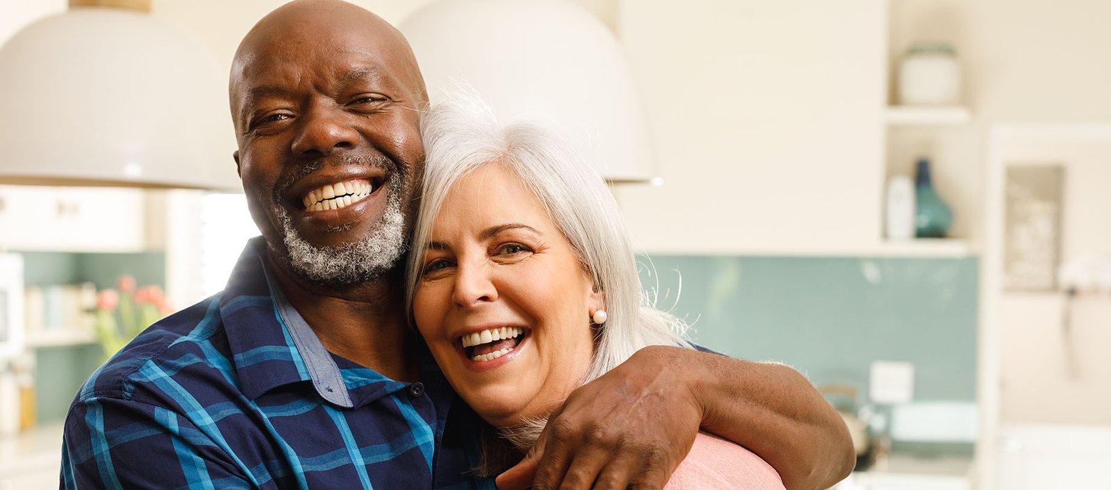 Smiling mature couple, both country club or wellness club members, enjoying a healthy meal in the kitchen at home using recipes from the Alterra Health lifestyle platform.