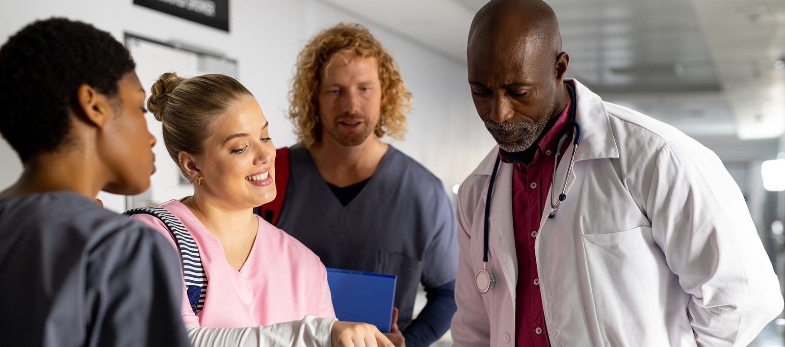 Group of medical providers in hospital using AI tools on tablet to improve patient lifestyle care and outcomes.
