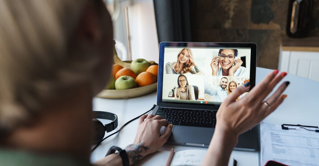 A person participates in a virtual employee wellness call on a laptop, with a bowl of fresh fruit on the desk, illustrating the concept of lifestyle-first care.